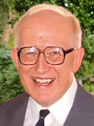 A head-and-shoulders photo of
                     Ray Edwards in suit and tie and with his glasses on